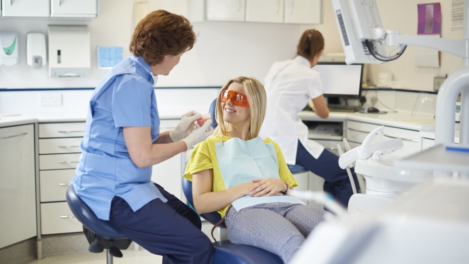 A dentist talks to a patient in the chair